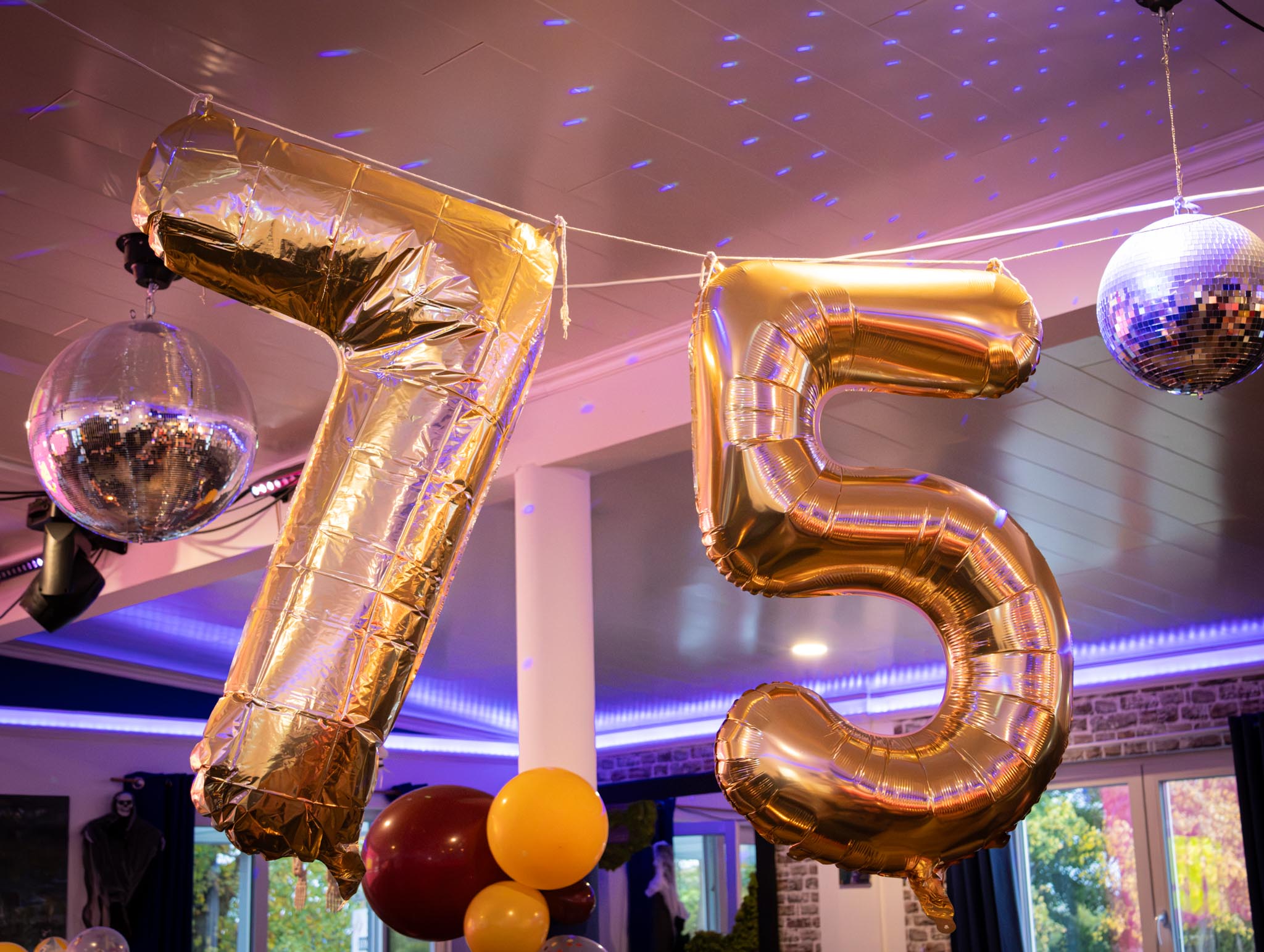 Goldene 75-Ballons und Discokugeln bei einer Geburtstagsfeier